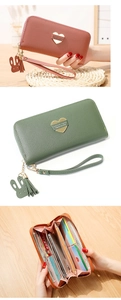 Detail view of pink, green, and brown leather wallets with heart logo and tassels