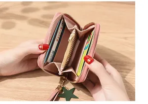 Detail of pink zip wallet showing multi-card slots and striped lining with star charm