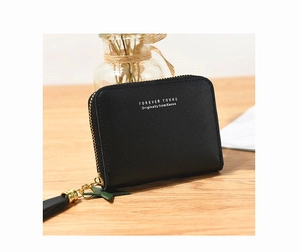 Detail of black faux leather mini wallet with litchi texture and elegant tassel charm