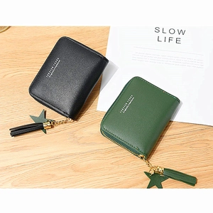 Detail of square zip wallets with star tassel charms in black and forest green leather