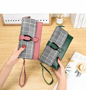 Detalle de carteras largas rosas y verdes con diseño de pata de gallo y hebillas de herradura