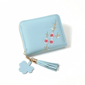 Portefeuille en cuir PU bleu clair avec broderie florale et pompon sur fond blanc