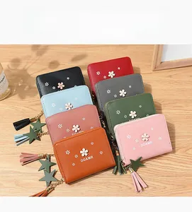 Short zipper flower wallets shown in 8 colors with star charms and tassels on a wooden table