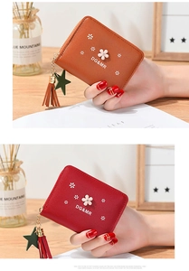 Close-up of small zipper purses with 3D flower decor and leather tassel charms