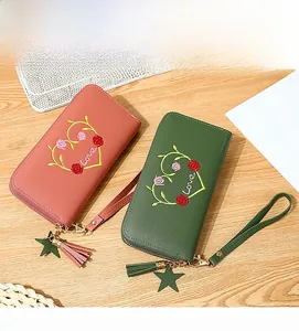 Detail of heart and rose embroidery on long zip-around wallet with fringe tassel