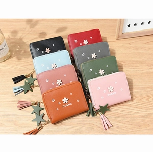 Close-up of colorful PU leather flower wallets with tassel stars on wooden desk