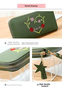 Detail of dark green long wallet with heart floral embroidery and star tassel zipper