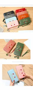 Close-up of long zip-around wallets with heart floral embroidery and star tassel detail