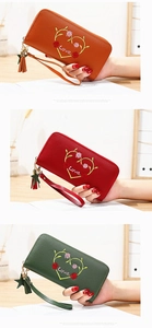 Detail of colorful long zip wallets with rose embroidery and star tassel charms
