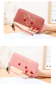 Close-up of heart floral embroidery and star tassel detail on long zipper wallet