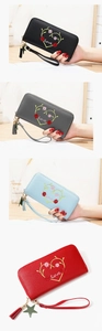 Detail of embroidered heart and 'Love' lettering on women's faux leather zip wallets