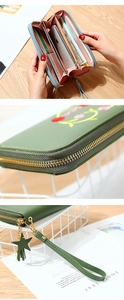 Macro detail of embroidered heart wallet featuring multiple card slots and zipper closure