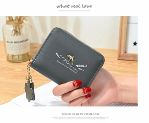 Close-up of grey leather wallet featuring a golden dolphin ornament and cute fish prints