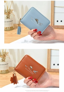 Detail of short PU leather wallets with dolphin metal charms and tassel zipper pulls