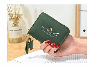 Detail of dark green leather coin purse with golden dolphin print and tassel zipper