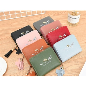 Close-up of colorful zippered short wallets featuring golden dolphin print and tassels