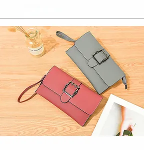 Close-up of litchi texture leather wallets in grey and burgundy with metal buckles