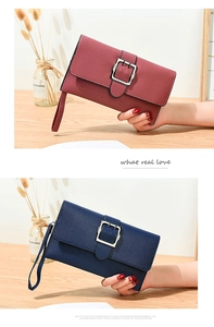 Detail view of long leather wallets in navy and dusty rose with large metal buckles