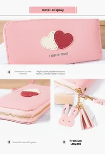 Detailed view of pink long wallet with litchi texture, heart pattern, and tassel charm