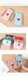 Detail of long soft leather wallet with double heart patch and tassel wristlet strap