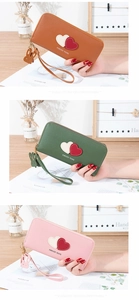 Detail of long soft leather wallets with heart pattern and cute rabbit charm in three colors