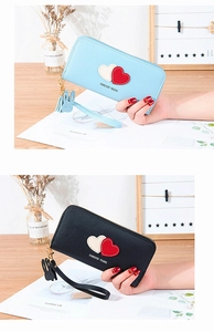 Detail of light blue and black long zip wallets with heart patches and rabbit charm