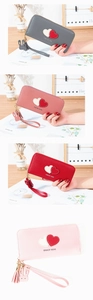 Detail of colorful long PU leather wallets featuring double heart patches and tassels