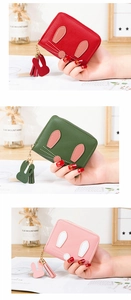 Macro detail of mini rabbit zip purses with cute ear decor and tassel charms in three colors
