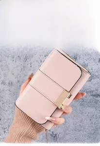 Detail of pink PU leather messenger bag featuring parallel stitching and gold metal buckle