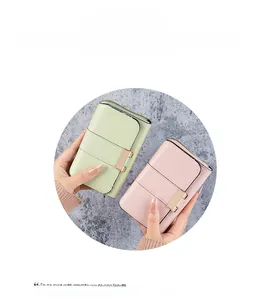 Detail of slim PU leather wallets in mint and pink featuring gold snap buttons and zippers