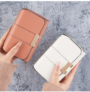 Close-up of pink and white PU leather wallets with horizontal grain and gold hardware