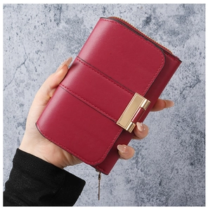 Detail of dark red matte leather wallet featuring horizontal stitching and gold-tone zipper