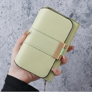 Detail of pistachio green long wallet featuring a metal buckle and fine stitching details