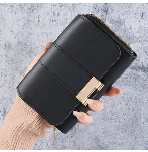 Detail of black matte faux leather wallet with gold metal buckle and top zipper closure