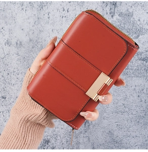 Detail of reddish-brown wallet with horizontal stitching and golden metal buckle