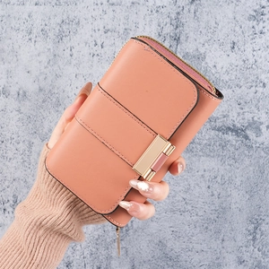 Detail of peach pink leather wallet with gold metal clasp and smooth zipper closure