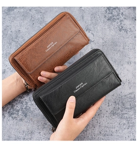 Men's large business wallet held by hand showing leather texture and zipper detail