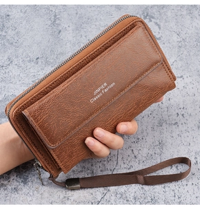 Close-up of brown textured leather men's clutch featuring a sturdy metal zipper and wrist strap
