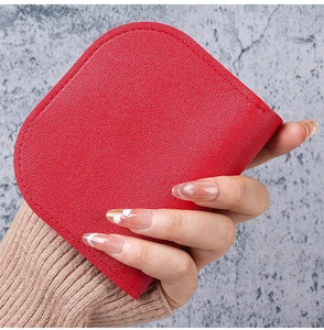 Primo piano di un piccolo porta carte in pelle rossa martellata con cuciture rifinite