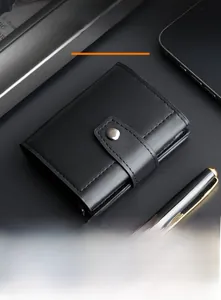 Detail of black leather pop-up card wallet with silver snap closure on business desk