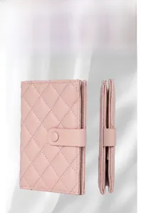 Detail view of pink quilted leather passport wallet with caviar texture and snap closure