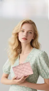 Close-up of pink quilted faux leather passport wallet held by a model in a floral dress