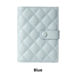 Detail of baby blue quilted passport holder with pebble leather texture and clasp closure