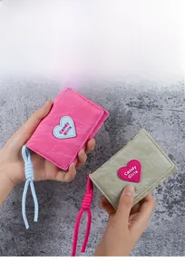 Close-up of small heart patch wallets with marble texture leather and rope lanyard