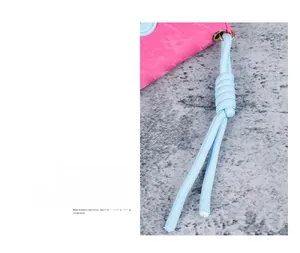 Pink lychee texture wallet with a contrasting light blue braided rope strap and metal eyelet