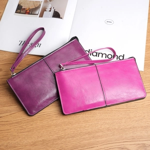 Women's long zip-around wallet with wristlet strap in purple and pink textured faux leather