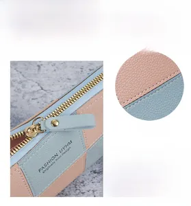 Detail of pink and blue lychee leather patchwork wallet with gold metal zipper