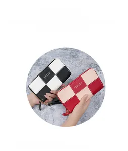 Detail view of large checkered patchwork clutch wallet with secure gold zipper and wrist strap