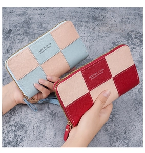 Close-up of long patchwork leather wallets featuring lychee texture and wrist strap