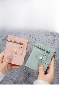 Detail of pink and green slim zipper wallets with snap buttons and stitching